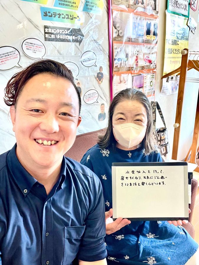 院長と女性の患者さん　ホワイトボードに「水素吸入を行って、痩せやすくなり、元気にジム通いをして生活を楽しんでいます」