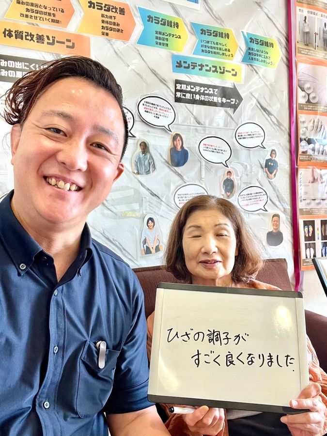 院長と女性の患者さん　ホワイトボードに「ひざの調子がすごく良くなりました」